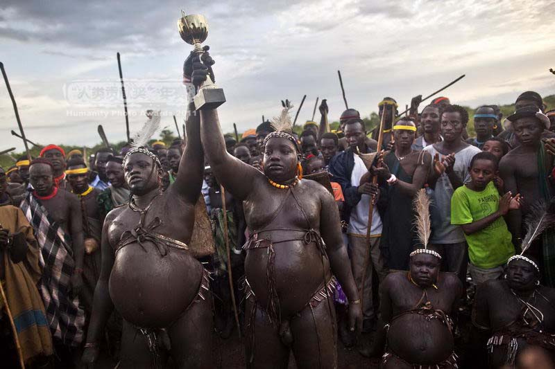 Ethiopia, May 2010. The two winners of the fat man competition of the Bode tribe to celebrate the 'Kel"(Bodi New year Celebration). The Bode is the name of a semi-nomadic tribe leaving in the Omo valley, about 140 km from the Ethiopian town of Jinka. Their homeland is remoted, located in the bush at the south west Omo valley. This celebration is a bit different than a usual new year celebration¡¯s as the tradition is to feed young men from every Bodi village. They are feeded only with cow blood and milk during 3-6 months ( fatning process). They manage then to almost double their weight, being then ready for the competition.of the fattest man. On the competition day, they arrive to the Bode  King village and after the dance they are measured by the elders who then decide who is the winner and the fattest. Ph: Wolberg  , text -Pavel wolberg